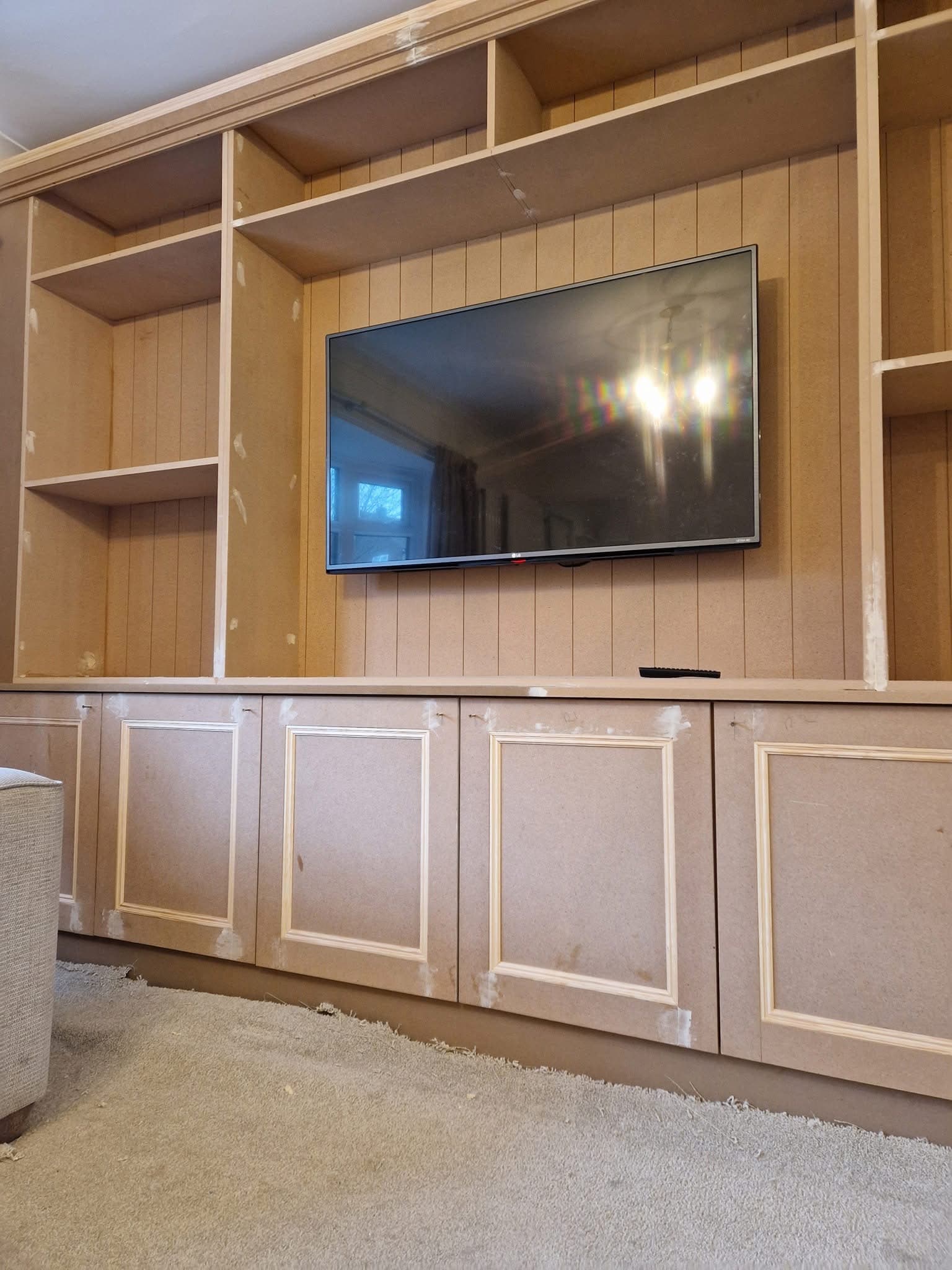 Custom wood panel TV wall with shelving